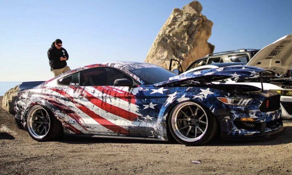 Ford Mustang colantat integral cu design steag american, expus în aer liber